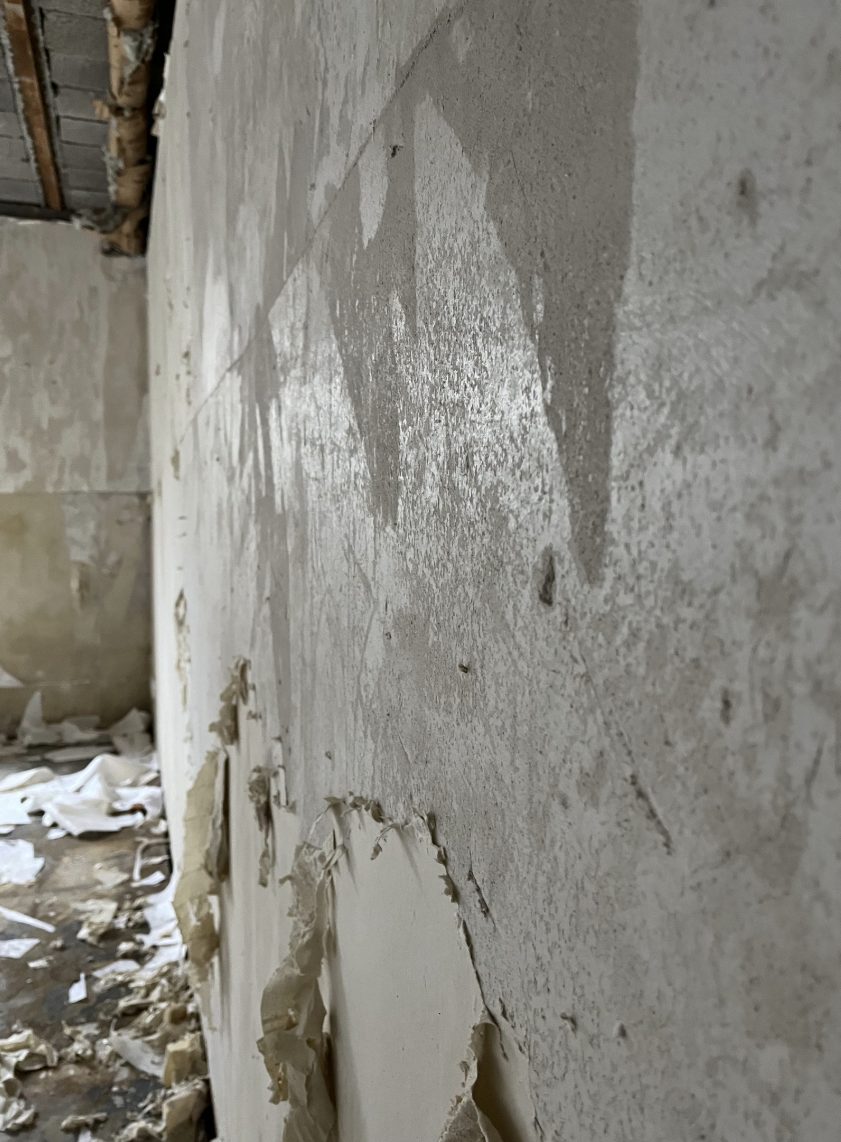 Bis auf den Putz freigelegte Wand nach dem Tapetenabriss